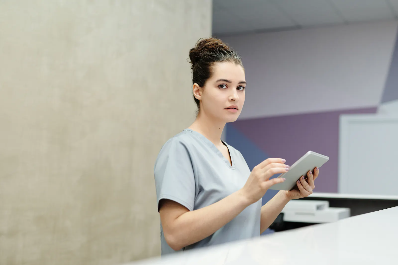 Recepcionista usando tablet em ambiente de atendimento