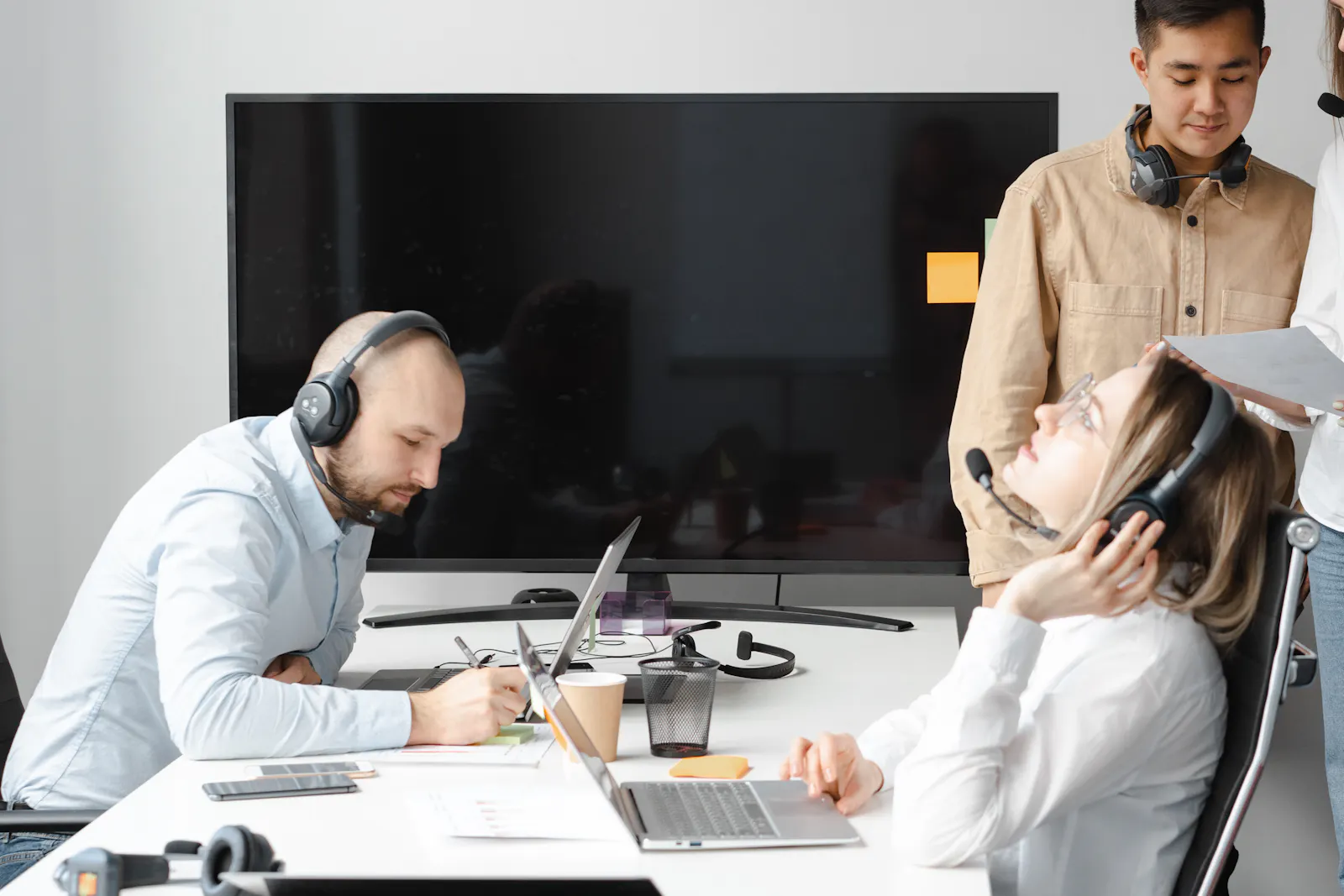 Equipe de atendimento usando notebooks e headsets