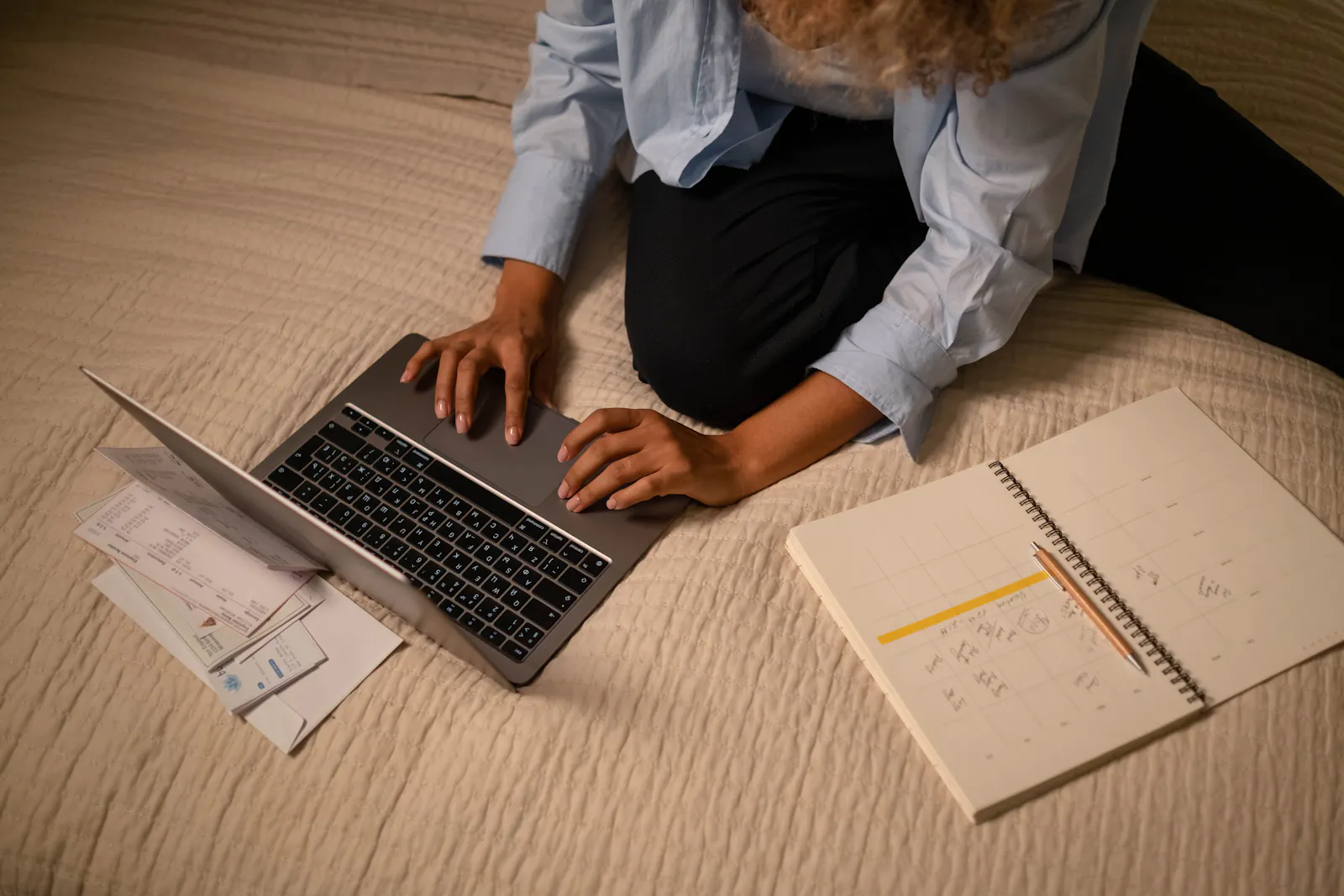 Profissional organizando tarefas, documentos e calendário ao lado do laptop